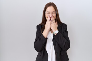 Beautiful brunette woman wearing business jacket and glasses laughing and embarrassed giggle...