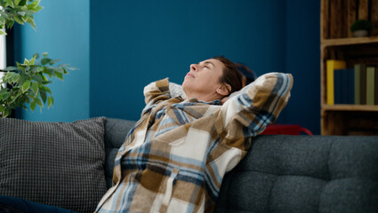 Obraz premium Middle age hispanic woman relaxed with hands on head sitting on sofa at home