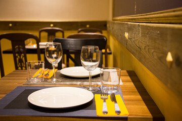 Elegant restaurant table with cutlery, crockery and glasses.