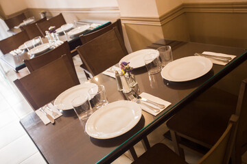 Elegant restaurant table with cutlery, crockery and glasses.