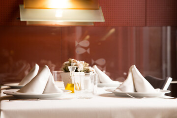 Elegant restaurant table with cutlery, crockery and glasses.