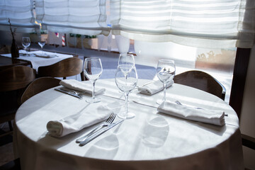 Elegant restaurant table with cutlery, crockery and glasses.