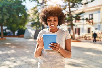 African american woman smiling confident using touchpad at park