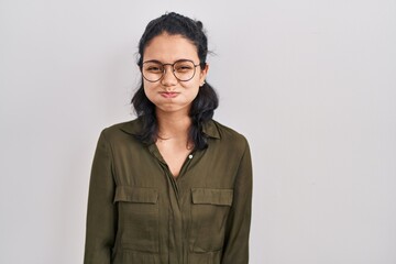 Hispanic woman with dark hair standing over isolated background puffing cheeks with funny face. mouth inflated with air, crazy expression. - obrazy, fototapety, plakaty