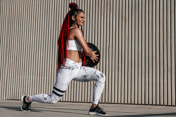 Athletic woman doing Lunge exercises with med ball. Strength and motivation.Photo of sporty  woman in fashionable sportswear