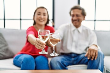 Middle age man and woman couple smiling confident toasting with champagne at home
