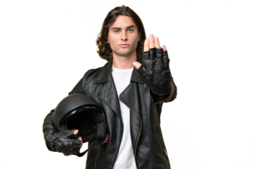 Young handsome man with a motorcycle helmet isolated on green chroma background making stop gesture
