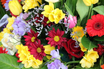 Bunte Blumen formatfüllende auf dem Friedhof nach Beerdigung im Trauerkranz