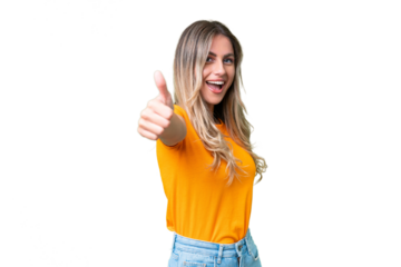 Young Uruguayan woman over isolated background with thumbs up because something good has happened