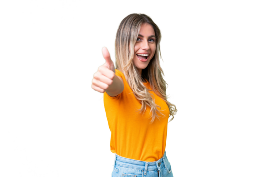 Young Uruguayan woman over isolated background with thumbs up because something good has happened
