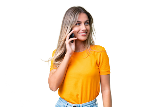 Young Uruguayan woman over isolated background keeping a conversation with the mobile phone with someone