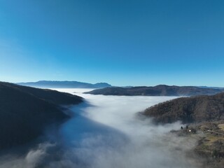 Aerial View. Flying over the high mountains in beautiful clouds. Aerial Drone camera shot. Air pollution clouds over Sarajevo in Bosnia and Herzegovina. 