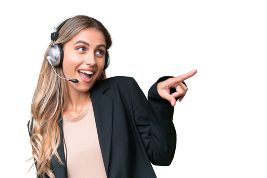 Telemarketer pretty Uruguayan woman working with a headset over isolated background pointing finger to the side and presenting a product