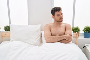 Fototapeta na wymiar Young hispanic man unhappy sitting on bed at bedroom