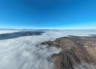 Aerial View. Flying over the high mountains in beautiful clouds. Aerial Drone camera shot. Air pollution clouds over Sarajevo in Bosnia and Herzegovina. 