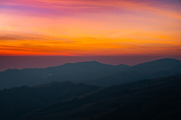 Panorama Aerial view sunset , sunrise over dark mountain with fog over the ground.The early evening sun illuminates the mountains and valleys.