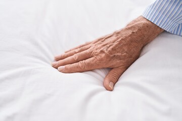 Middle age grey-haired man touching blanket at street