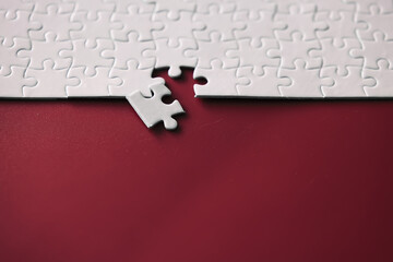 Clean puzzle elements on the red background. Empty puzzle piece on the table. Teamwork concept.