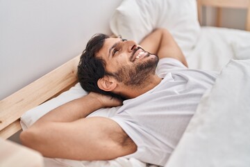 Fototapeta na wymiar Young hispanic man smiling confident lying on bed at bedroom