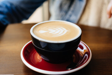 Cappuccino coffee mug close up decorated on top of foam.