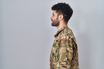 Arab man wearing camouflage army uniform looking to side, relax profile pose with natural face and...