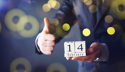 Hand holding wood cubes with 14 February date calendar. concept of Saint Valentine's.