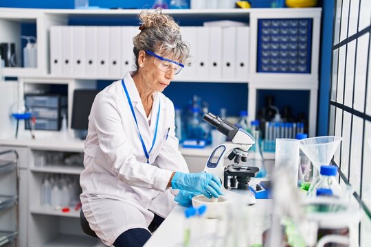 Middle age woman scientist mixing on bowl at laboratory