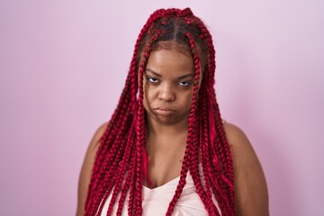 African american woman with braided hair standing over pink background looking sleepy and tired, exhausted for fatigue and hangover, lazy eyes in the morning.