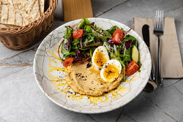 delicious hummus with greens and tomatoes
