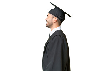 Young university graduate man over isolated background laughing in lateral position