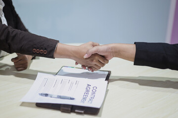 Close up of two businessman handshaking in office after contract agreement