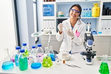 Young chinese woman wearing scientist uniform working at laboratory