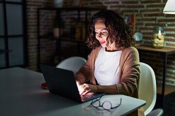Fototapeta na wymiar Middle age hispanic woman using laptop at night at home