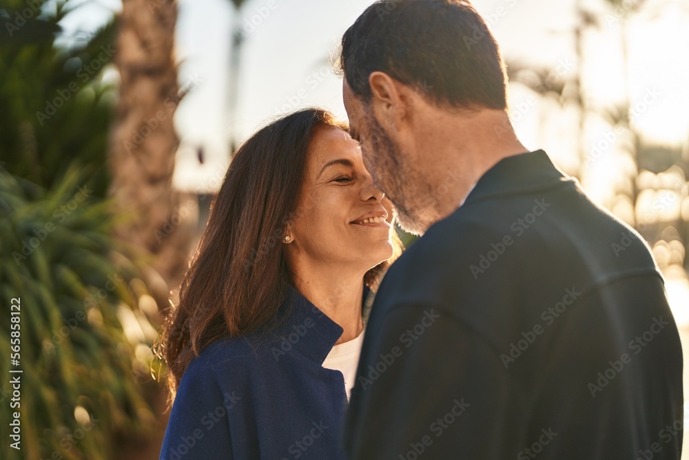 Poster Middle age man and woman couple standing together at park