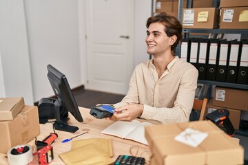 Young caucasian man ecommerce business worker using data phone and credit card at office