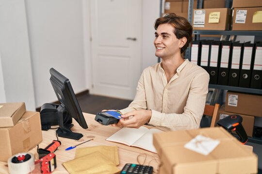 Young caucasian man ecommerce business worker using data phone and credit card at office