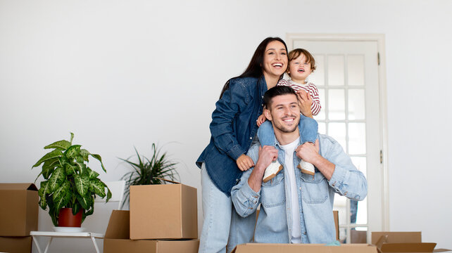 Family Housing. Happy Parents With Little Son Posing In New Home After Moving