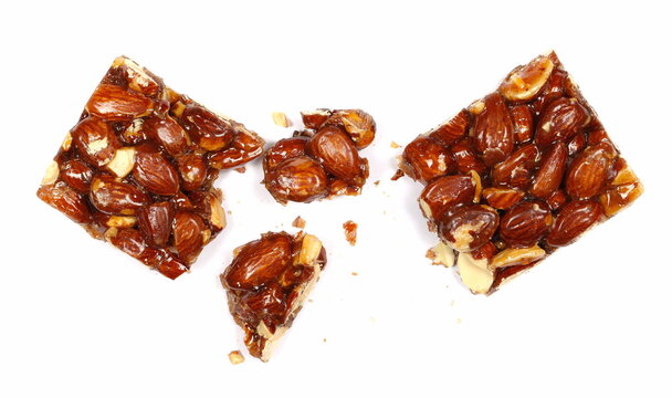 Almond caramelized nut, pieces candied bar isolated on white, top view