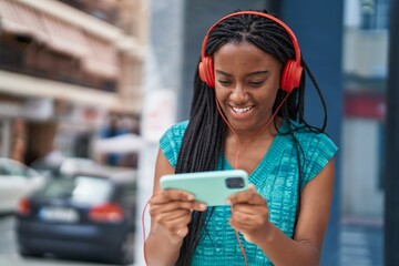 African american woman smiling confident playing video game at street © Krakenimages.com
