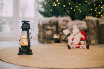 kerosene lantern stands in the foreground in front of a Christmas tree
