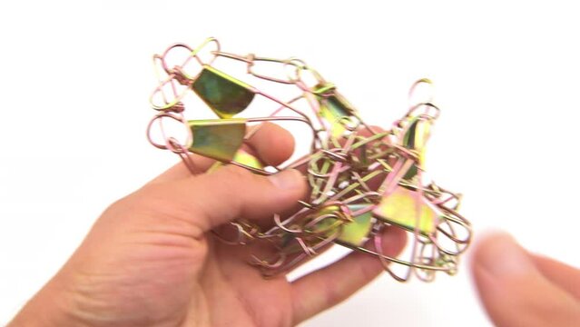 Fish chain stringer with clip metal string for fishing angling to catch food seafood, hand holding macro closeup on white background