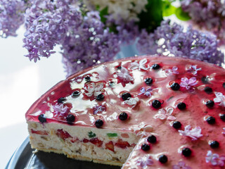 Fresh, unbaked cheesecake decorated with edible lilac flowers