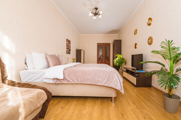 Fototapeta na wymiar the general plan of a spacious bright and modern bedroom in an apartment with a wide double bed and air conditioning