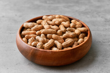 Image of bunch of peanuts in a bowl on a concrete surface