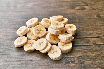 Photo of banana slices on a wooden table