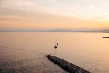 View of two sailboats in the north bay of Ceuta, in front of the chorrillo beach, at sunset.