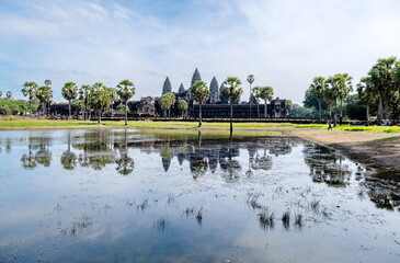 Fototapeta na wymiar Angkor Wat main facade has a beautiful reflection on the water pond.