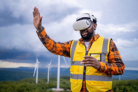 Portrait of engineer African American man working with VR headset in wind turbine farm.