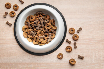 A bowl of dog food on a wooden floor.