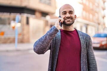 Young man smiling confident talking on the smartphone at street